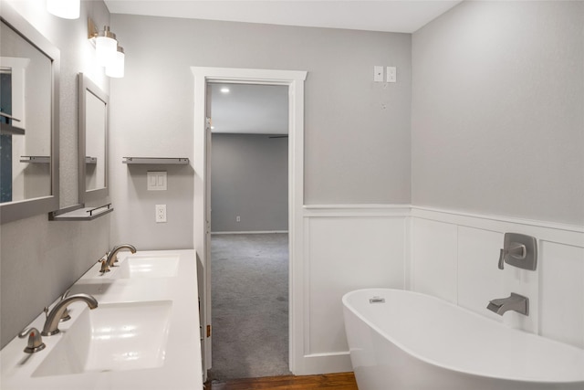 104 Charles Ln, Terrell, TX 75160 - bathroom with a freestanding tub, double vanity, and a wainscoted wall