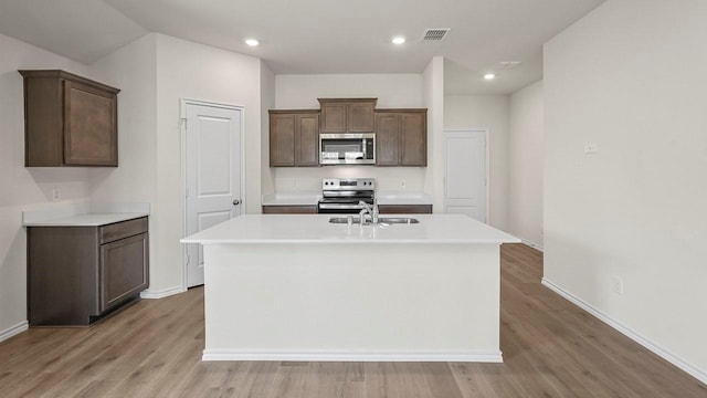441 Drake Dr, Ferris, TX 75125 - kitchen featuring stainless steel appliances, light wood-style floors, an island with sink, light countertops, and recessed lighting