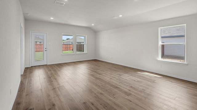 441 Drake Dr, Ferris, TX 75125 - empty room with wood-type flooring, vaulted ceiling, and recessed lighting
