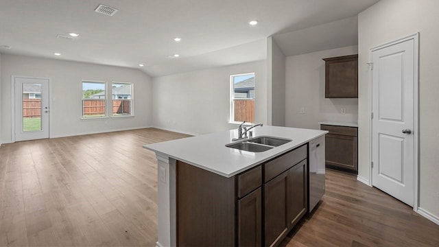 441 Drake Dr, Ferris, TX 75125 - kitchen featuring wood finished floors, light countertops, a kitchen island with sink, dishwasher, and dark brown cabinetry