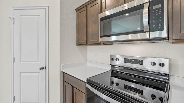 441 Drake Dr, Ferris, TX 75125 - kitchen with stainless steel appliances, light countertops, and dark brown cabinets