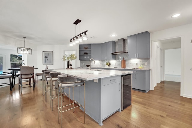 6910 Midcrest Dr, Dallas, TX 75254 - kitchen featuring beverage cooler, wall chimney range hood, gray cabinetry, decorative backsplash, and recessed lighting