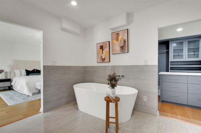 6910 Midcrest Dr, Dallas, TX 75254 - ensuite bathroom with a soaking tub, wood finished floors, and recessed lighting