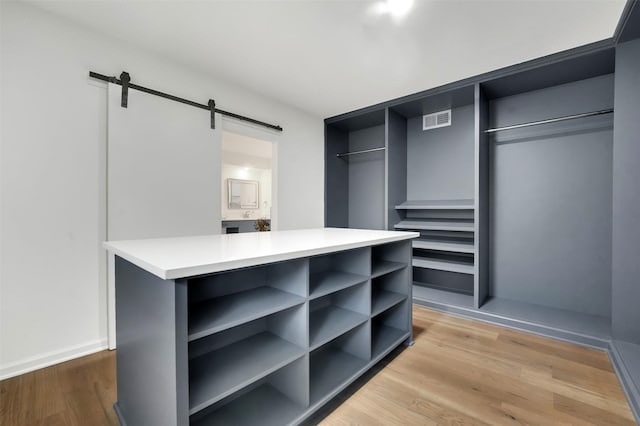 6910 Midcrest Dr, Dallas, TX 75254 - walk in closet featuring a barn door and light wood-type flooring