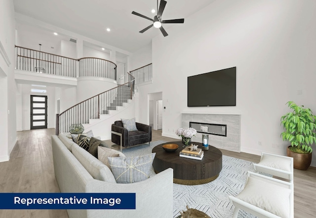 2113 Rockhopper Ct, Mansfield, TX 76063 - living room with a towering ceiling, wood finished floors, stairs, ceiling fan, and recessed lighting