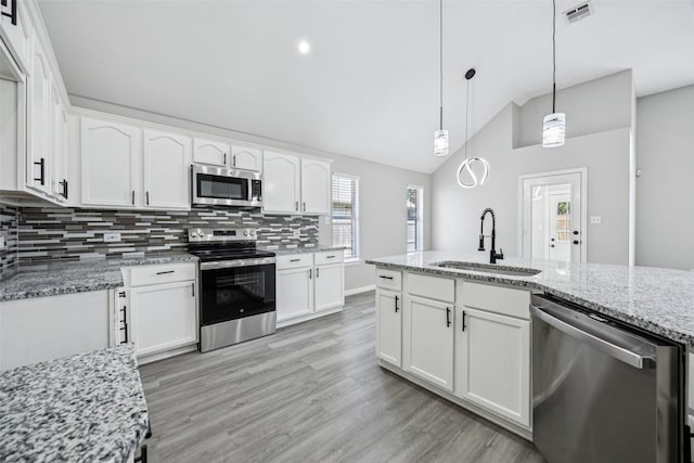 6945 Stockton Dr, Fort Worth, TX 76132 - kitchen featuring stainless steel appliances, lofted ceiling, tasteful backsplash, white cabinetry, and light stone countertops