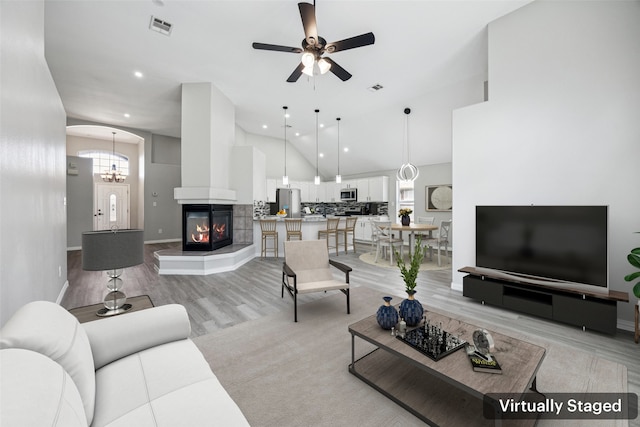 6945 Stockton Dr, Fort Worth, TX 76132 - living area with a ceiling fan, a multi sided fireplace, light wood-style flooring, recessed lighting, and high vaulted ceiling