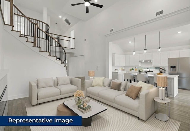1403 Heron St, Mansfield, TX 76063 - living area with light wood-style floors, high vaulted ceiling, ceiling fan, stairway, and recessed lighting