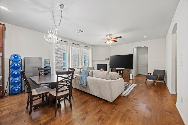 2025 Meliana Dr, Little Elm, TX 75068 - living room featuring arched walkways, a ceiling fan, a warm lit fireplace, dark wood-style flooring, and recessed lighting