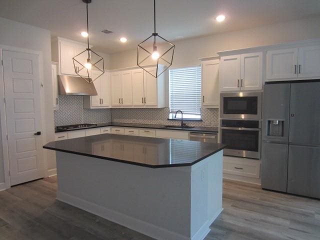 1813 Terrace Way, Argyle, TX 76226 - kitchen featuring appliances with stainless steel finishes, under cabinet range hood, dark countertops, white cabinets, and dark wood-style floors