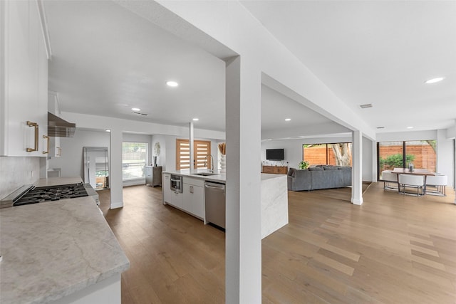 12211 Quincy Ln, Dallas, TX 75230 - kitchen featuring appliances with stainless steel finishes, white cabinets, recessed lighting, open floor plan, and light wood finished floors