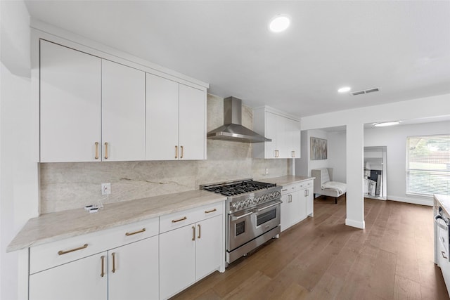 12211 Quincy Ln, Dallas, TX 75230 - kitchen featuring range with two ovens, wall chimney exhaust hood, wood finished floors, tasteful backsplash, and recessed lighting