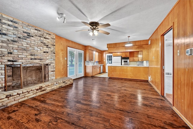 12906 Fm 902, Dorchester, TX 75459 - kitchen with brown cabinetry, a peninsula, wooden walls, dark wood finished floors, and ceiling fan