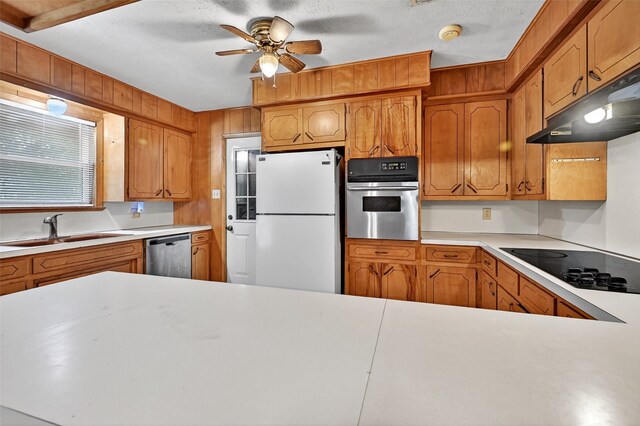 12906 Fm 902, Dorchester, TX 75459 - kitchen featuring appliances with stainless steel finishes, under cabinet range hood, light countertops, a ceiling fan, and brown cabinetry