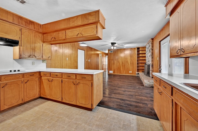 12906 Fm 902, Dorchester, TX 75459 - kitchen with a peninsula, light countertops, a ceiling fan, black electric stovetop, and wood walls