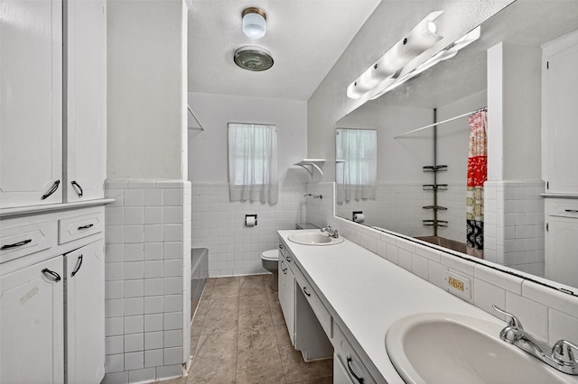 12906 Fm 902, Dorchester, TX 75459 - full bath featuring a shower with shower curtain, double vanity, tile walls, a tub to relax in, and wainscoting