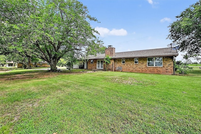 12906 Fm 902, Dorchester, TX 75459 - rear view of property with a chimney, brick siding, and a lawn