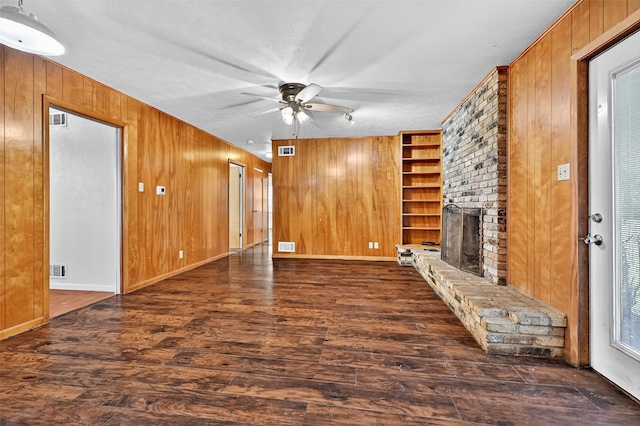 12906 Fm 902, Dorchester, TX 75459 - unfurnished living room with wooden walls, a ceiling fan, a brick fireplace, wood finished floors, and built in features