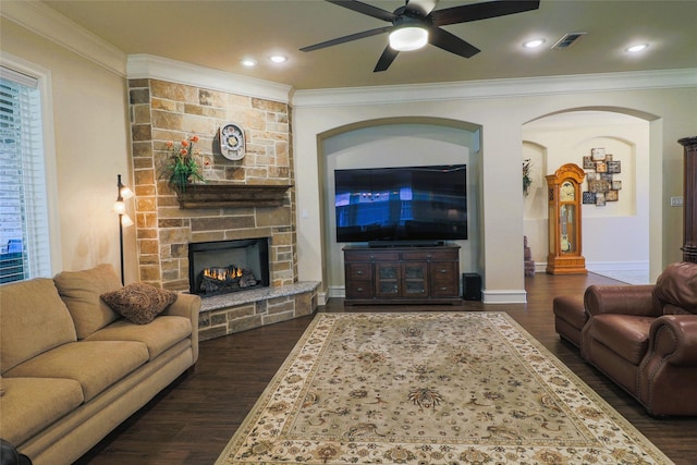 6923 Saint Anthony Dr, Tyler, TX 75703 - living room featuring ornamental molding, ceiling fan, dark wood finished floors, and a stone fireplace