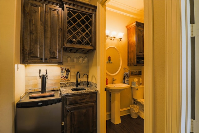 6923 Saint Anthony Dr, Tyler, TX 75703 - indoor wet bar featuring backsplash, crown molding, dark wood finished floors, and refrigerator