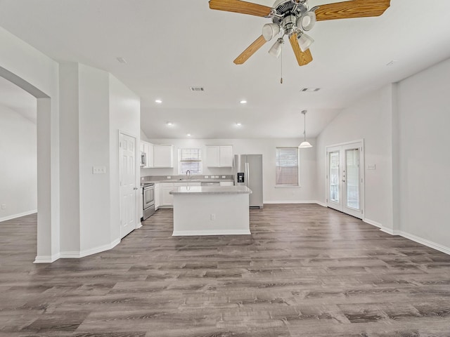 8705 Autumn Creek Trl, Fort Worth, TX 76134 - kitchen with appliances with stainless steel finishes, open floor plan, vaulted ceiling, a kitchen island, and dark wood finished floors