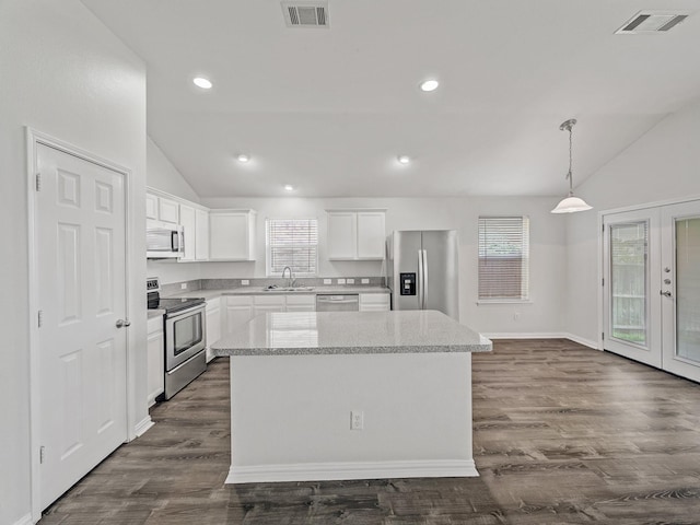 8705 Autumn Creek Trl, Fort Worth, TX 76134 - kitchen with appliances with stainless steel finishes, lofted ceiling, a kitchen island, white cabinets, and recessed lighting