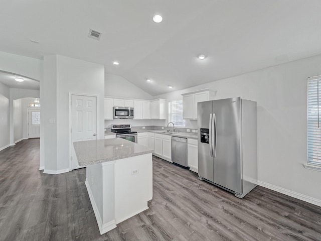8705 Autumn Creek Trl, Fort Worth, TX 76134 - kitchen featuring stainless steel appliances, dark wood-style floors, vaulted ceiling, white cabinetry, and a kitchen island