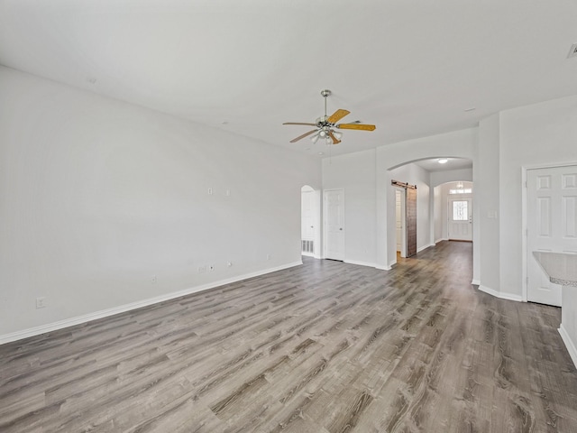 8705 Autumn Creek Trl, Fort Worth, TX 76134 - unfurnished living room with arched walkways, ceiling fan, and wood finished floors