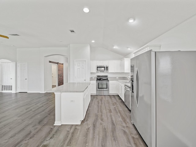 8705 Autumn Creek Trl, Fort Worth, TX 76134 - kitchen with stainless steel appliances, a barn door, light wood-style flooring, a center island, and lofted ceiling