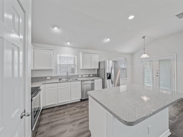 8705 Autumn Creek Trl, Fort Worth, TX 76134 - kitchen featuring appliances with stainless steel finishes, wood finished floors, white cabinetry, lofted ceiling, and french doors