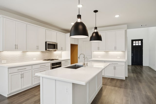 2819 Grand Lookout Ln, Arlington, TX 76001 - kitchen with stainless steel appliances, dark wood finished floors, a center island with sink, white cabinetry, and recessed lighting