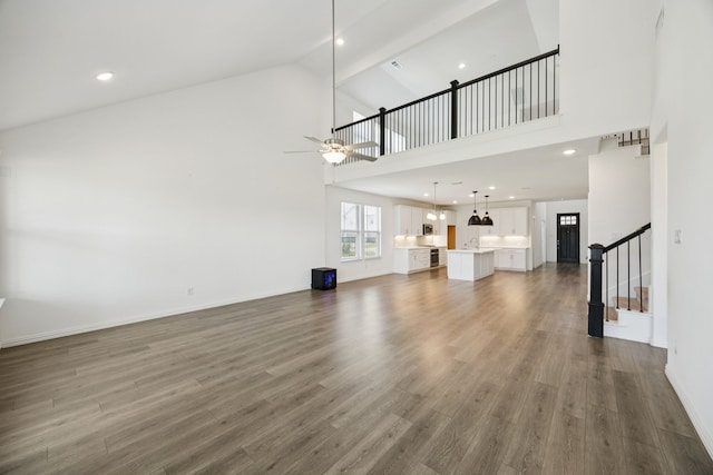 2819 Grand Lookout Ln, Arlington, TX 76001 - unfurnished living room with ceiling fan, high vaulted ceiling, wood finished floors, and stairway