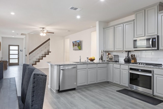 18137 Lakefront Ct, Forney, TX 75126 - kitchen featuring stainless steel appliances, gray cabinetry, a peninsula, light wood finished floors, and recessed lighting