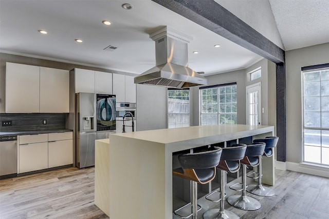 6111 Pinwood Cir, Arlington, TX 76001 - kitchen with island range hood, appliances with stainless steel finishes, a center island, light wood finished floors, and a breakfast bar