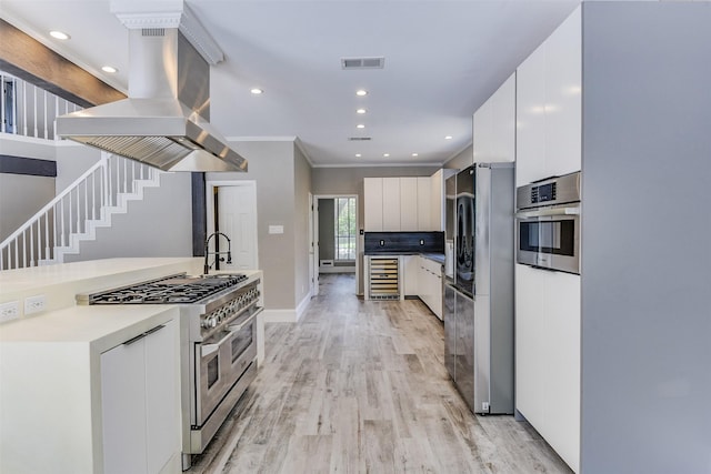 6111 Pinwood Cir, Arlington, TX 76001 - kitchen featuring appliances with stainless steel finishes, island exhaust hood, wine cooler, modern cabinets, and light wood-style flooring