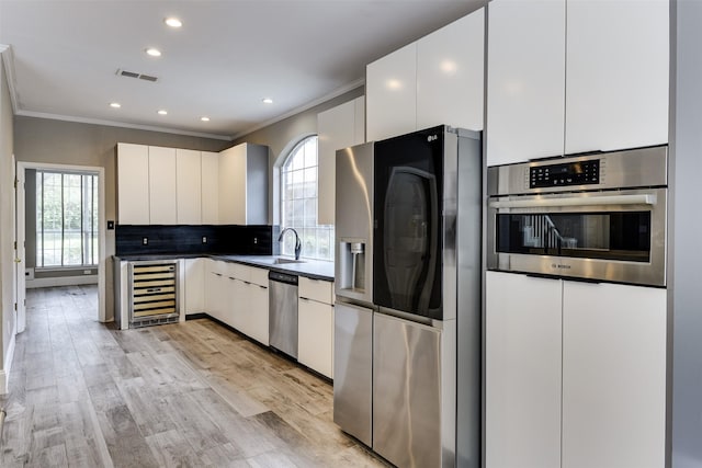 6111 Pinwood Cir, Arlington, TX 76001 - kitchen featuring stainless steel appliances, wine cooler, crown molding, healthy amount of natural light, and decorative backsplash