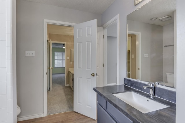 6111 Pinwood Cir, Arlington, TX 76001 - bathroom featuring vanity, wood finished floors, a textured ceiling, and a ceiling fan