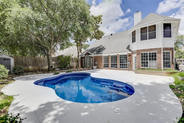 6111 Pinwood Cir, Arlington, TX 76001 - view of pool featuring a patio area, a fenced backyard, and a storage shed