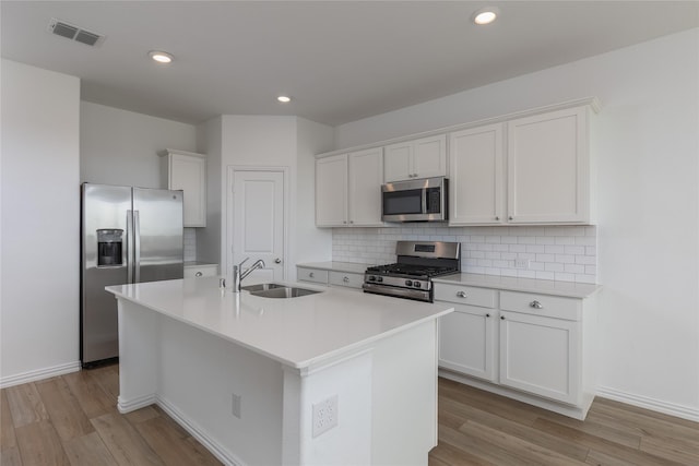 204 Post Oak St, Azle, TX 76020 - kitchen featuring stainless steel appliances, light wood-type flooring, a kitchen island with sink, decorative backsplash, and recessed lighting