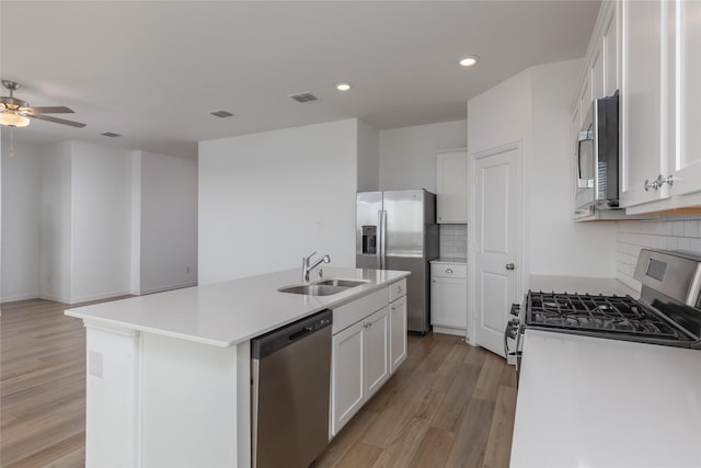 204 Post Oak St, Azle, TX 76020 - kitchen with stainless steel appliances, light wood-type flooring, backsplash, an island with sink, and white cabinets