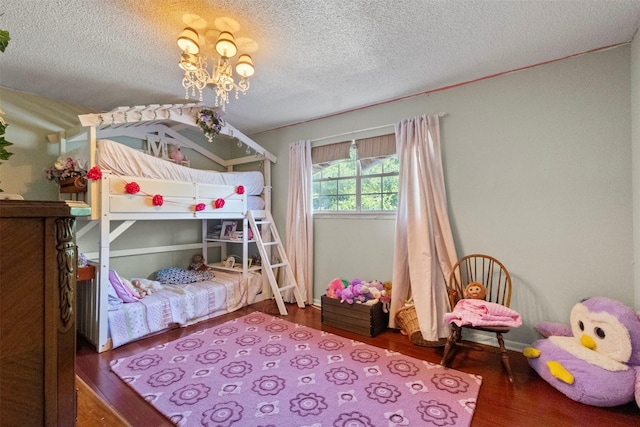 1605 Lamberth Cir, Sherman, TX 75092 - bedroom featuring wood finished floors, a textured ceiling, and a chandelier