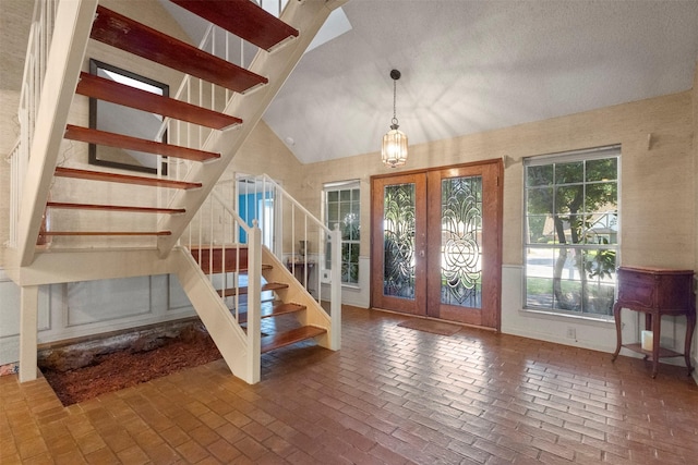1605 Lamberth Cir, Sherman, TX 75092 - foyer entrance with french doors, brick floors, stairs, and lofted ceiling