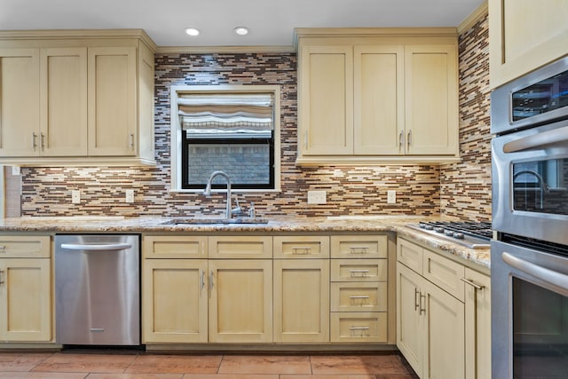 505 Buckingham Pl, Tyler, TX 75701 - kitchen with cream cabinets, stainless steel appliances, backsplash, light stone counters, and recessed lighting