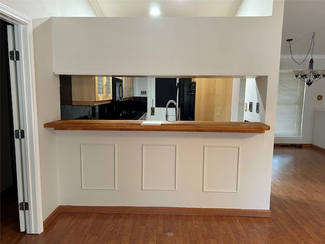 216 Lemon Dr, Arlington, TX 76018 - kitchen featuring black appliances, wood finished floors, and a chandelier
