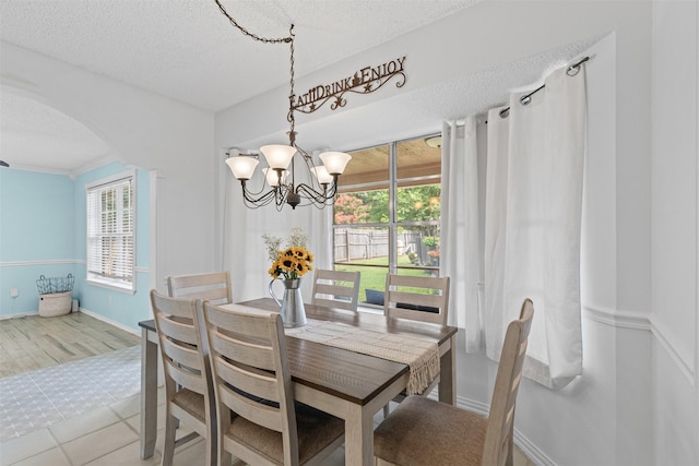 6737 Oliver Dr, North Richland Hills, TX 76180 - dining room with a chandelier, arched walkways, healthy amount of natural light, and a textured ceiling