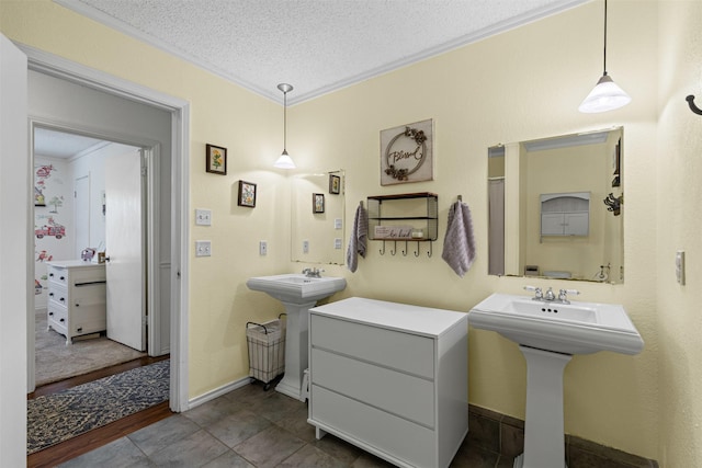 6737 Oliver Dr, North Richland Hills, TX 76180 - bathroom featuring a textured ceiling, ornamental molding, tile patterned floors, and two sinks