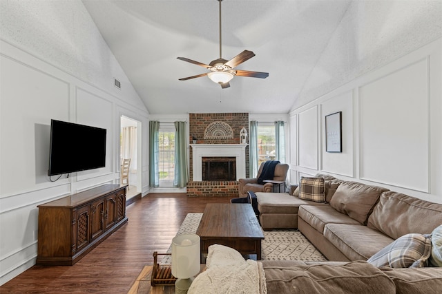 6737 Oliver Dr, North Richland Hills, TX 76180 - living area with a decorative wall, vaulted ceiling, a ceiling fan, dark wood finished floors, and a brick fireplace