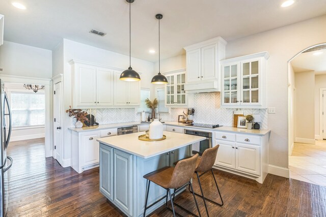 210 Walker Ct N, Waxahachie, TX 75167 - kitchen featuring appliances with stainless steel finishes, white cabinets, a center island, light countertops, and backsplash