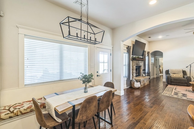 210 Walker Ct N, Waxahachie, TX 75167 - dining area featuring arched walkways, dark wood-style floors, a fireplace, a ceiling fan, and recessed lighting