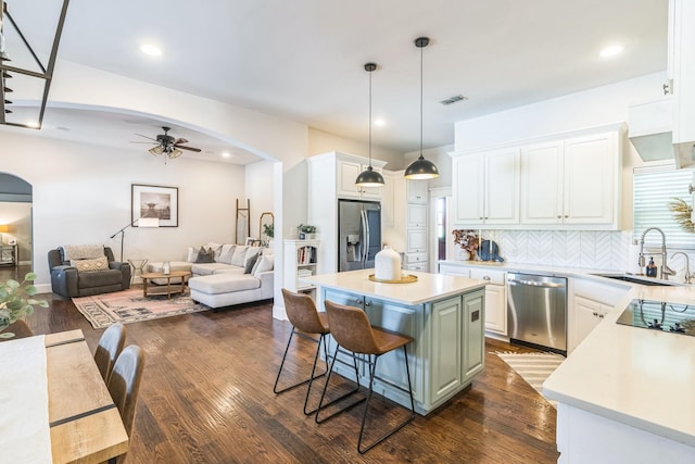 210 Walker Ct N, Waxahachie, TX 75167 - kitchen with stainless steel appliances, arched walkways, a ceiling fan, open floor plan, and a center island
